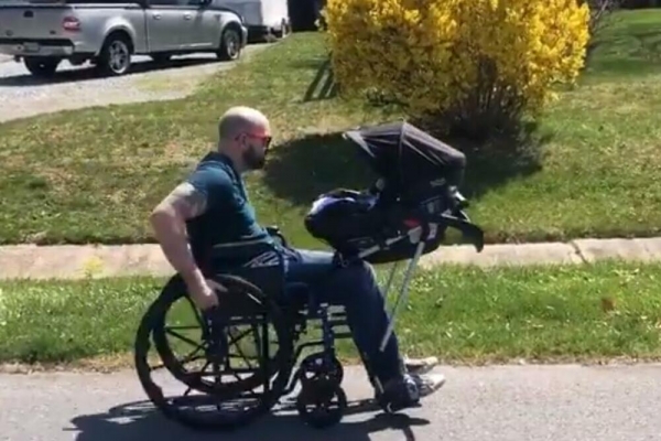 Otac s invaliditetom u samostalnoj šetnji s bebom uz pomoć auto-sjedišta